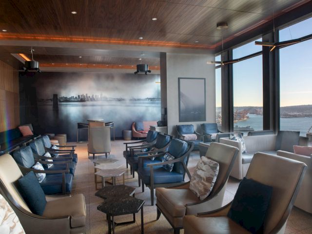 A spacious lounge with comfortable seating and large windows offering a city view.